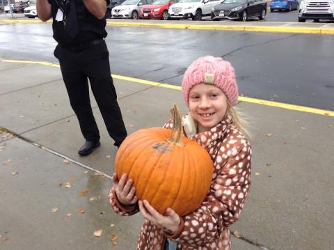 holding their big pumpkin