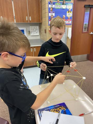 Students constructing bridges out of spaghetti noodles and marshmallows.