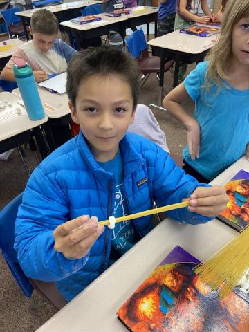 Students constructing bridges out of spaghetti noodles and marshmallows.